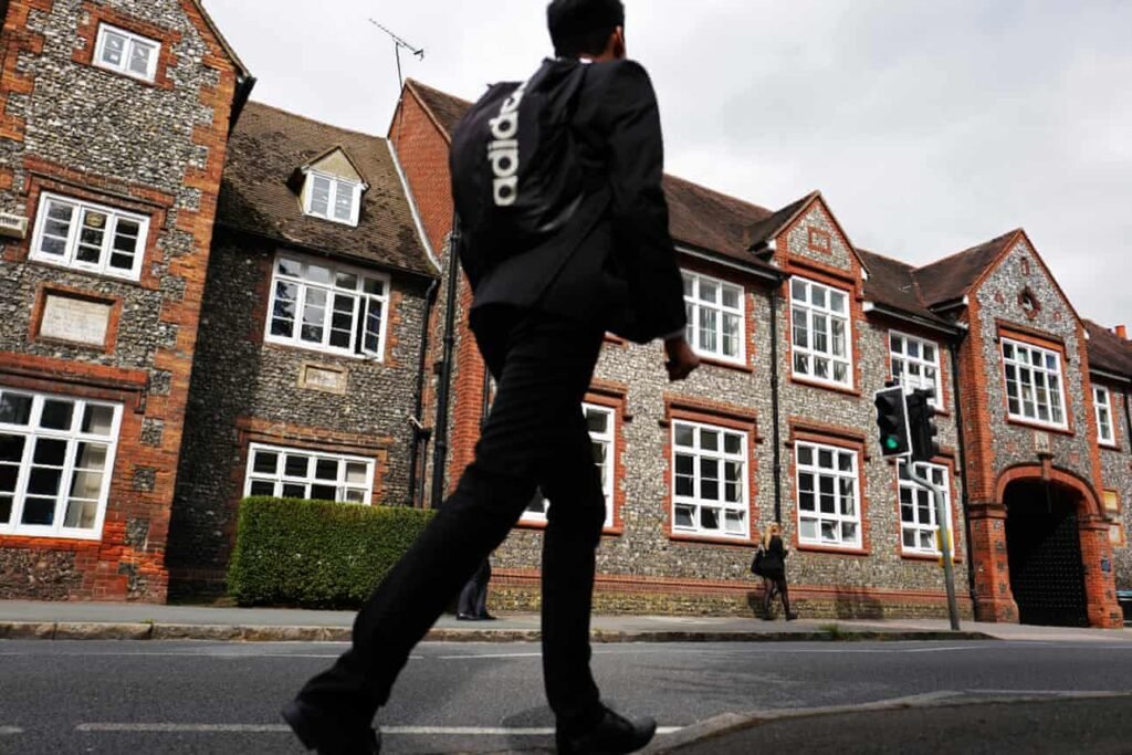 Boy in front of an old school building walking along to possibly go and sit the 11 plus exam.